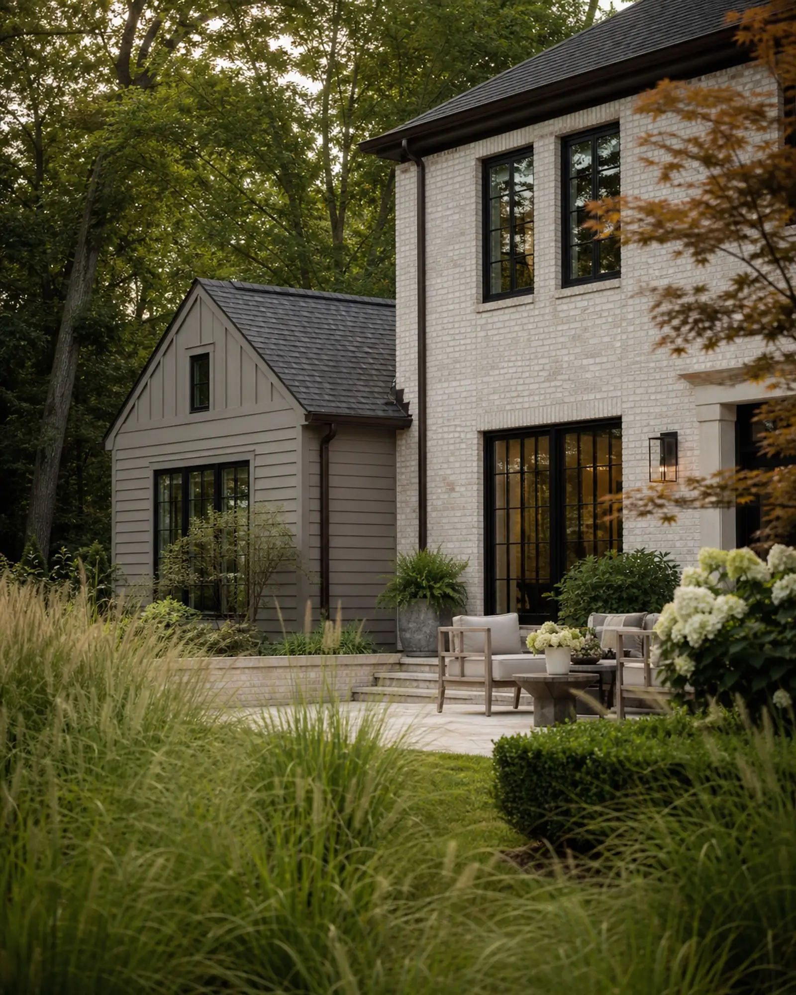 Cream brick and warm greige garden elevation with dark windows beneath mature trees — representative concept image