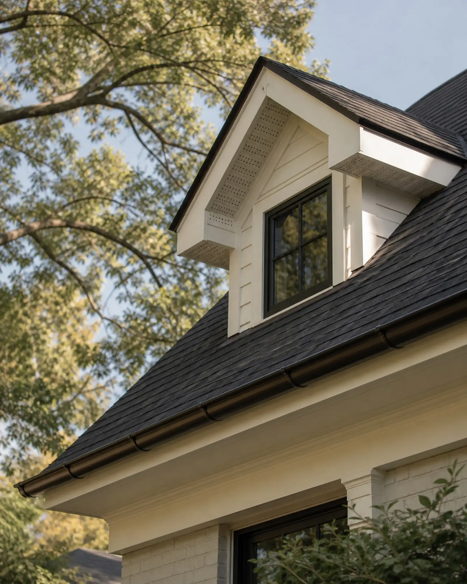 Charcoal dormer roof with vented soffit, crisp fascia, and half-round gutter — representative concept image