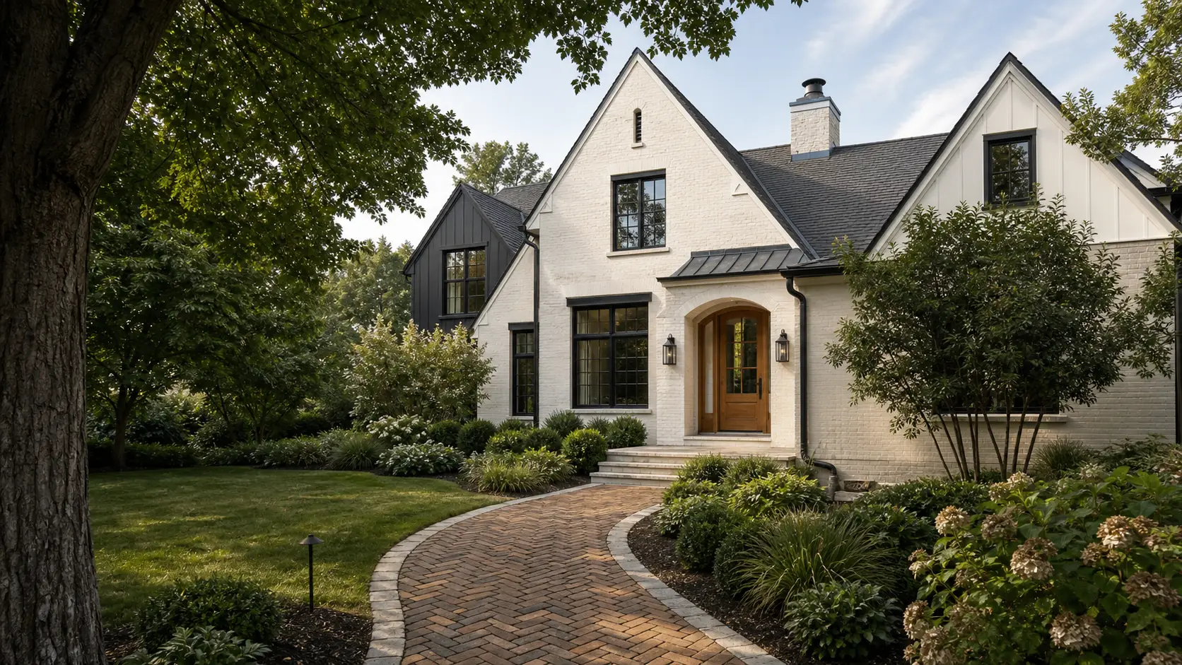 Approach along a brick walk to a limewashed-brick Central Ohio home with dark trim and mature landscaping — representative concept image