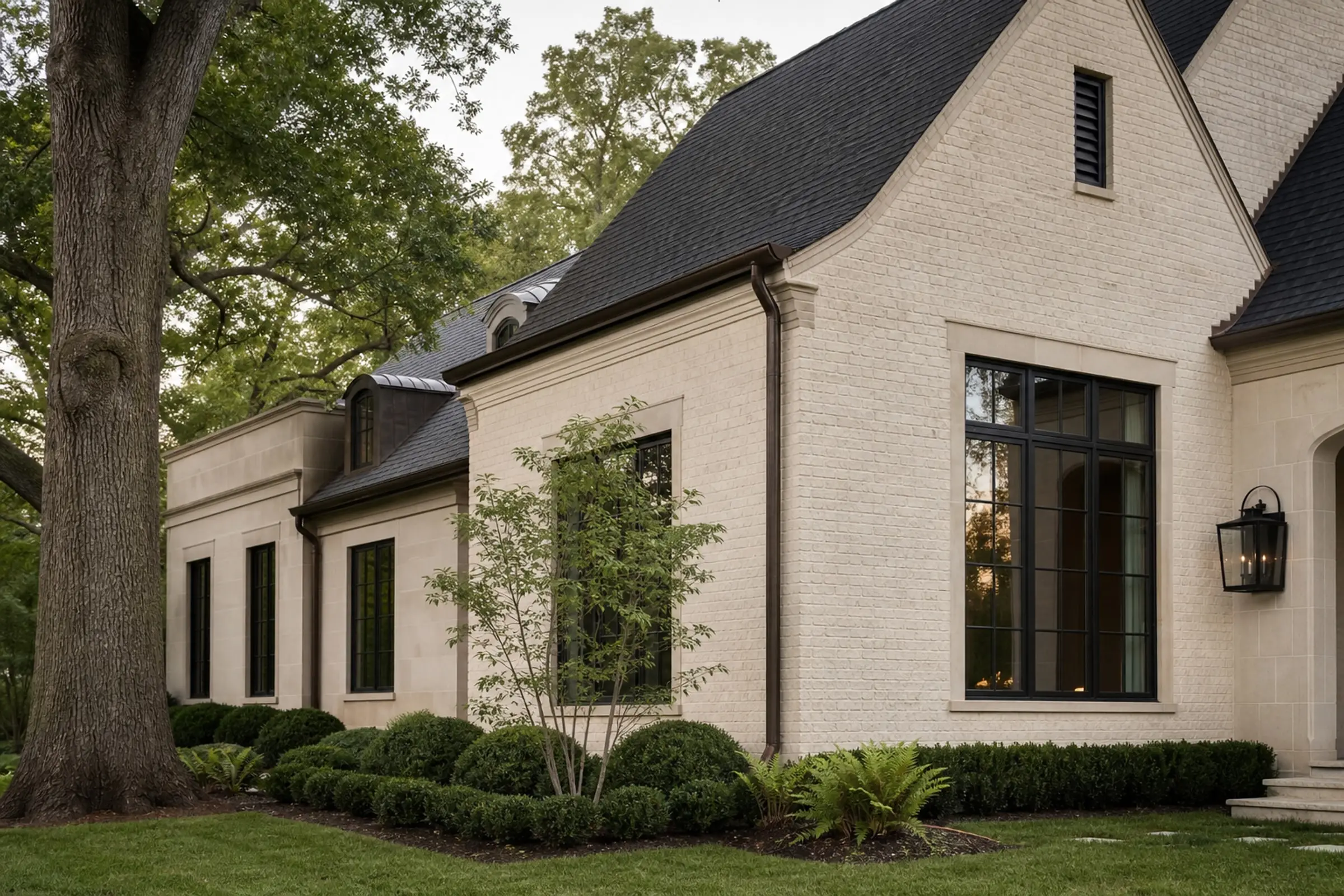 Cream masonry residence comparing near-black and warm bronze window tones in natural light — representative concept image
